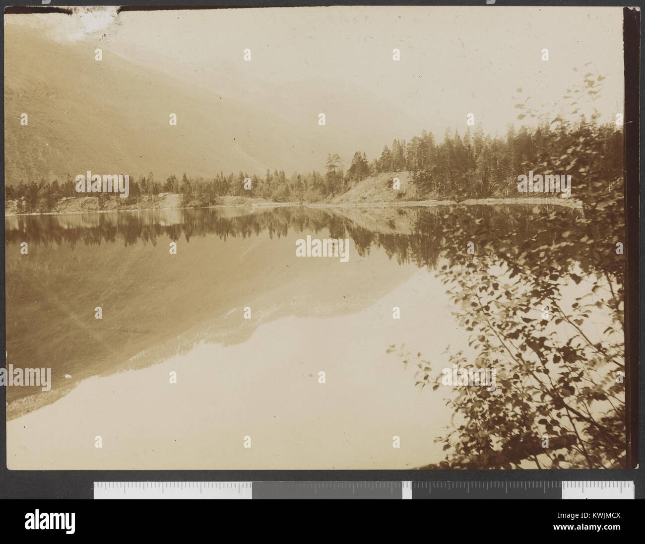 Une photographie en noir et blanc montrant le lac Juvusjärvi près de Gakko-Varre, probablement en Laponie, capturant des reflets sur l'eau et le paysage naturel environnant. Banque D'Images