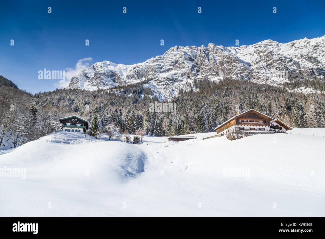 Vue panoramique de beaux paysages de montagne paysage hivernal dans les Alpes avec chalets de montagne traditionnels par une froide journée ensoleillée avec ciel bleu et clo Banque D'Images