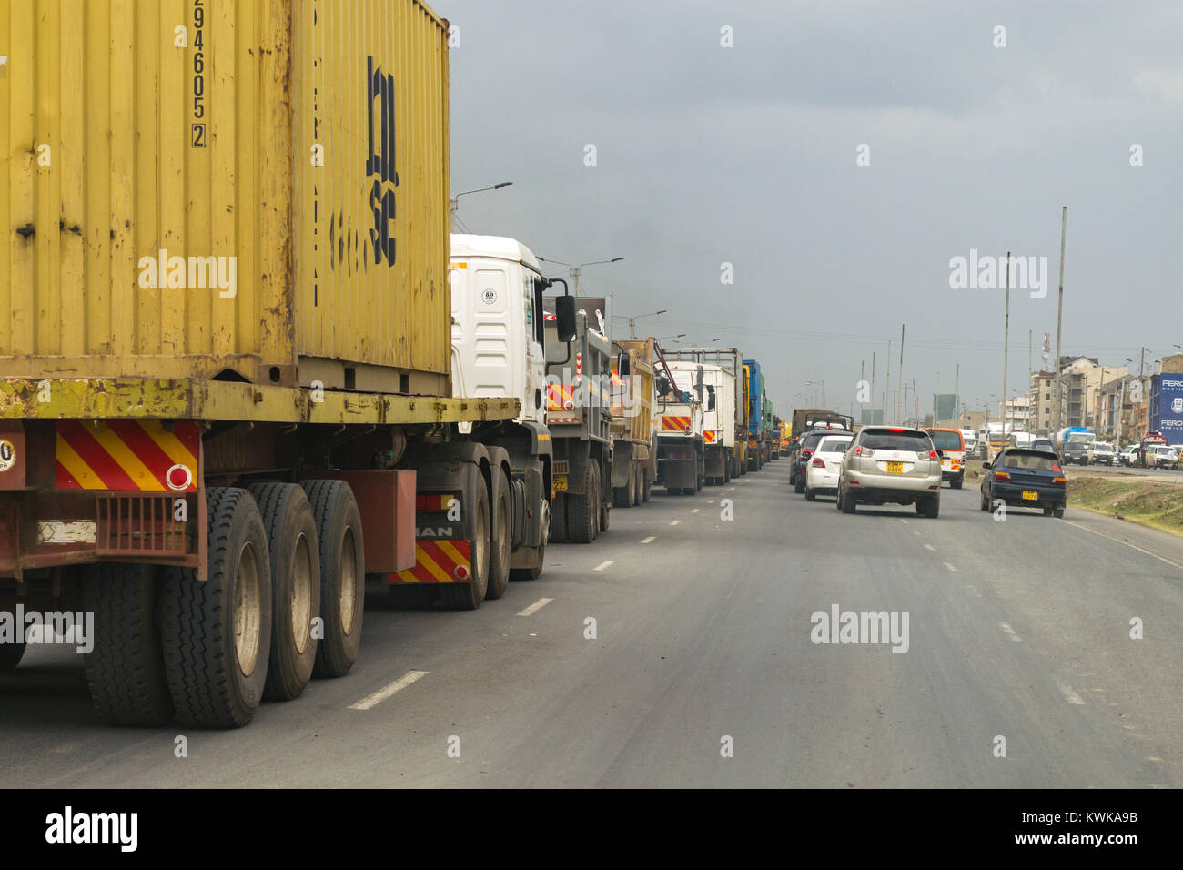 Une longue file de camions et de camions sur la route de Mombasa comme file d'attente à utiliser un pont-bascule plus loin sur la route, Kenya, Afrique de l'Est Banque D'Images