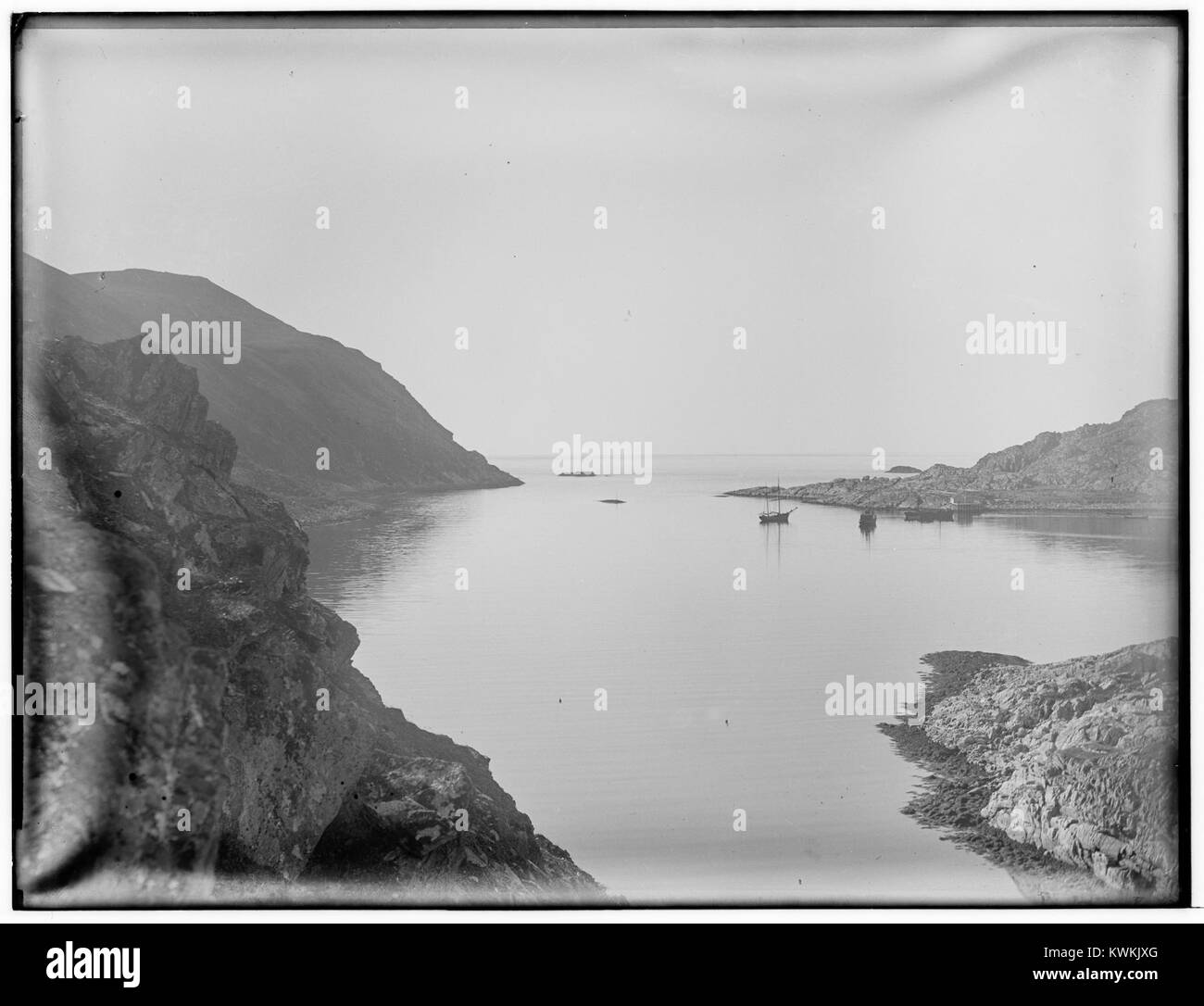 Photographie historique du port extérieur de Tufjord, Rolvsøya, comté de Finnmark, Norvège, montrant des bateaux et des bâtiments côtiers typiques des villages de pêcheurs du nord de la Norvège. Banque D'Images