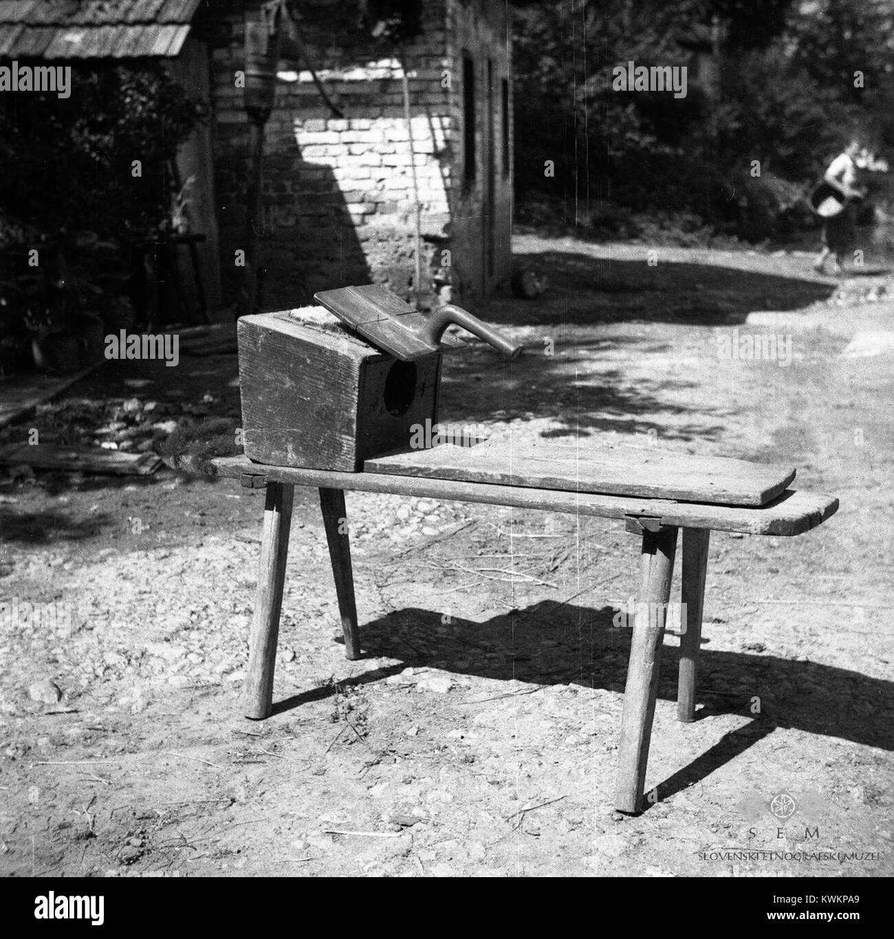 Une photographie de 1950 de Artiža vas montre une « rahla » - une boîte creuse en bois utilisée pour le cardage de la laine - aux côtés d'une brosse, illustrant les techniques traditionnelles de préparation des textiles dans les zones rurales de Slovénie. Banque D'Images