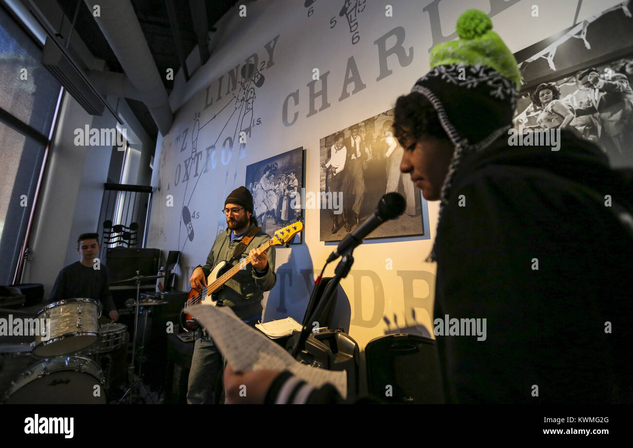 Davenport, Iowa, États-Unis. Dec 27, 2016. Leasman Randy instructeur de Davenport joue de la basse tandis que la chanteuse Charlotte Boyer, 13, Rock Island donne sur lyrics avant un verset et le batteur Jackson Schou, 15 ans, de Bettendorf conserve un beat au cours de la pratique de la musique sur le fleuve de l'expérience en construction à Davenport le Mardi, Décembre 27, 2016. Le Blues de l'hiver annuel instrumentales et vocales caractéristiques du programme des ateliers, ainsi qu'une concentration sur la composition et l'improvisation du blues. Les sessions sont ouvertes aux musiciens âgés de 8-18 et exécuter du lundi au jeudi avant de conclure dans un blues jam dans le Redsto Banque D'Images