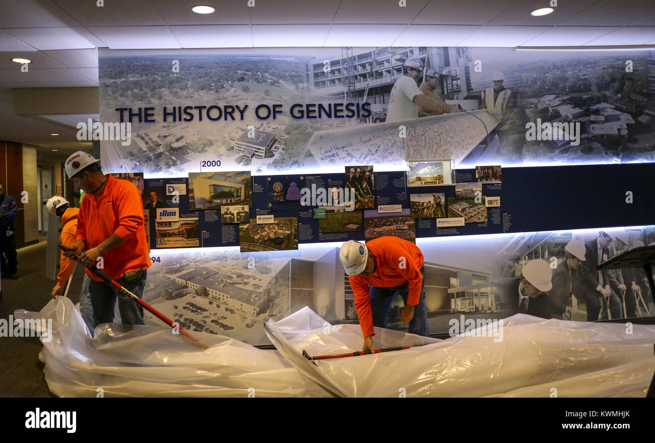 Davenport, Iowa, États-Unis. 7 Décembre, 2017. Moins de travailleurs une bâche qui entourait l'histoire mur à Genesis Medical Center East, Rusholme Street à Davenport le Jeudi, Décembre 7, 2017. La genèse a dévoilé une murale historique y compris les artefacts et l'information de près de 150 ans de l'histoire de la santé dans la région de Davenport. Credit : Andy Abeyta/Quad-City Times/ZUMA/Alamy Fil Live News Banque D'Images