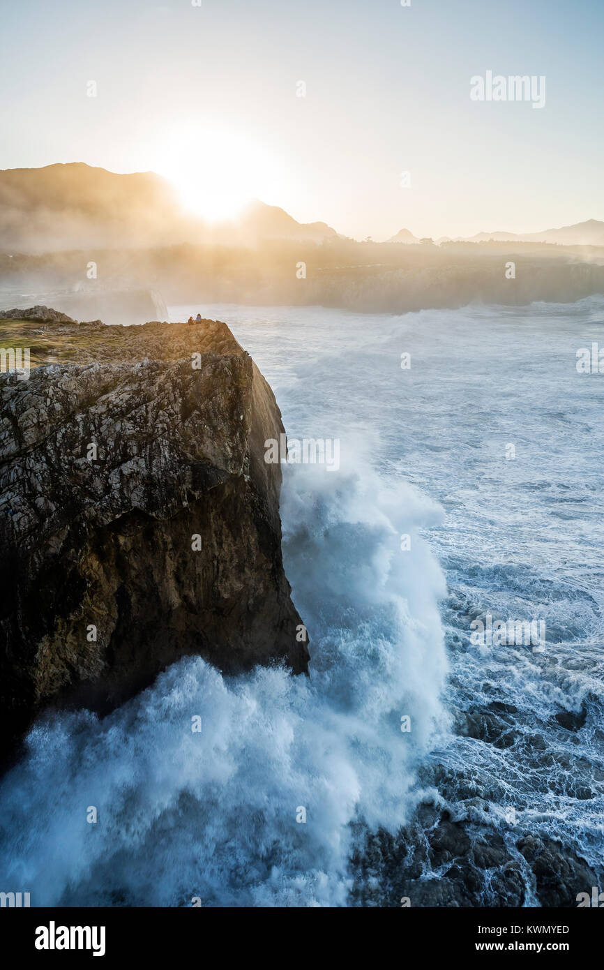 Coucher de soleil sur une falaise avec des vagues contre l'écrasement il Banque D'Images