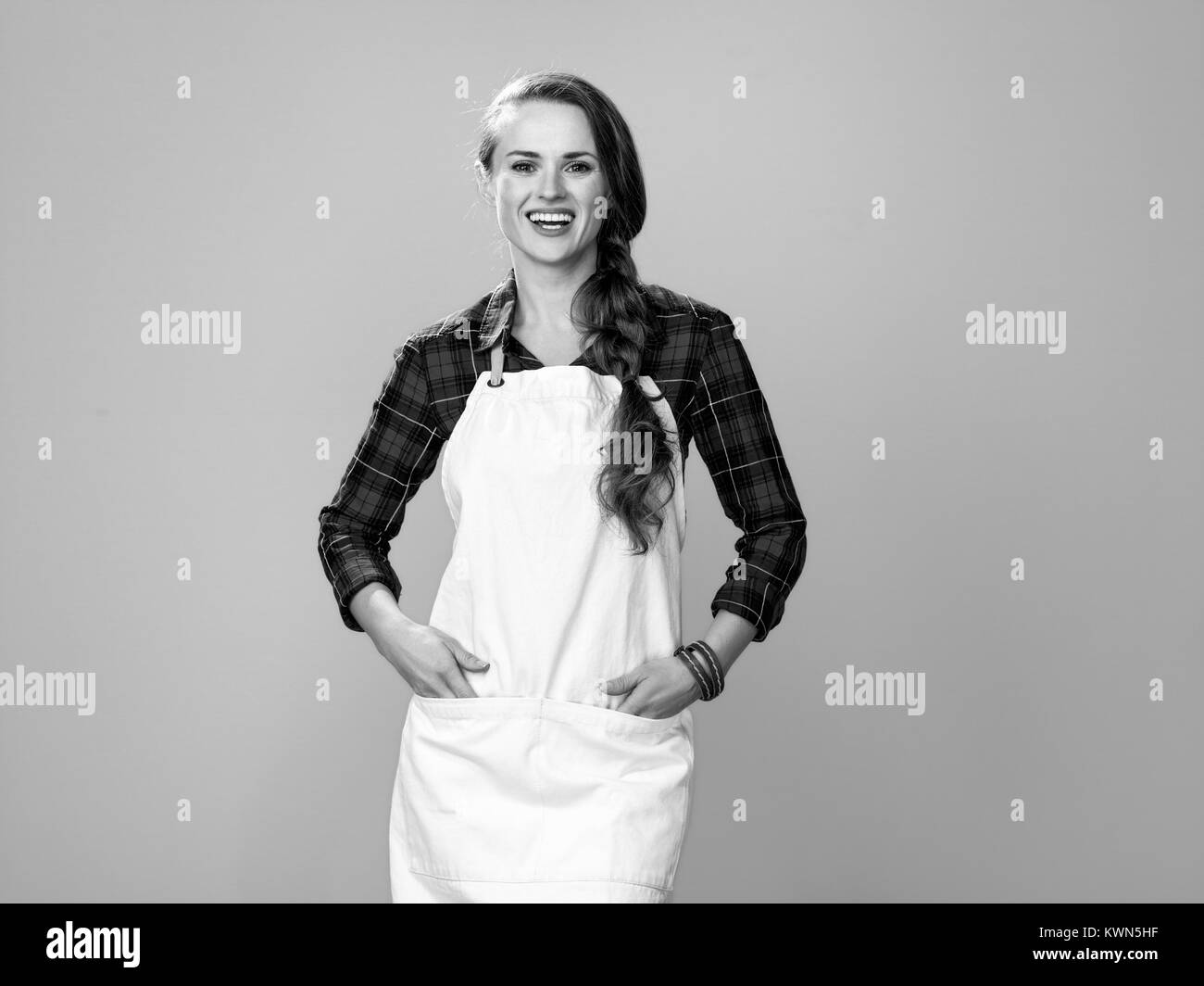 Des aliments sains à votre table. Portrait of happy young woman wearing apron agriculteur isolé sur le jaune Banque D'Images