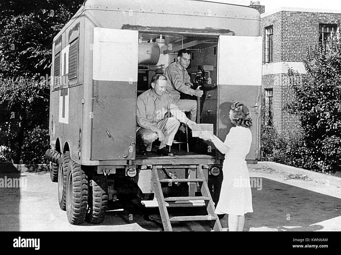 Cette image historique représente deux employés de la Croix-Rouge américaine distribuant des fournitures médicales à une femme d'une unité mobile, 1958. La Croix-Rouge américaine répond à plus de 67 000 catastrophes naturelles, y compris de maison ou appartement de forêt, des ouragans, inondations, tremblements de terre, tornades, les déversements de matières dangereuses, les accidents de transport, des explosions, et autres catastrophes naturelles et causées par l'homme. Image courtoisie CDC. Banque D'Images