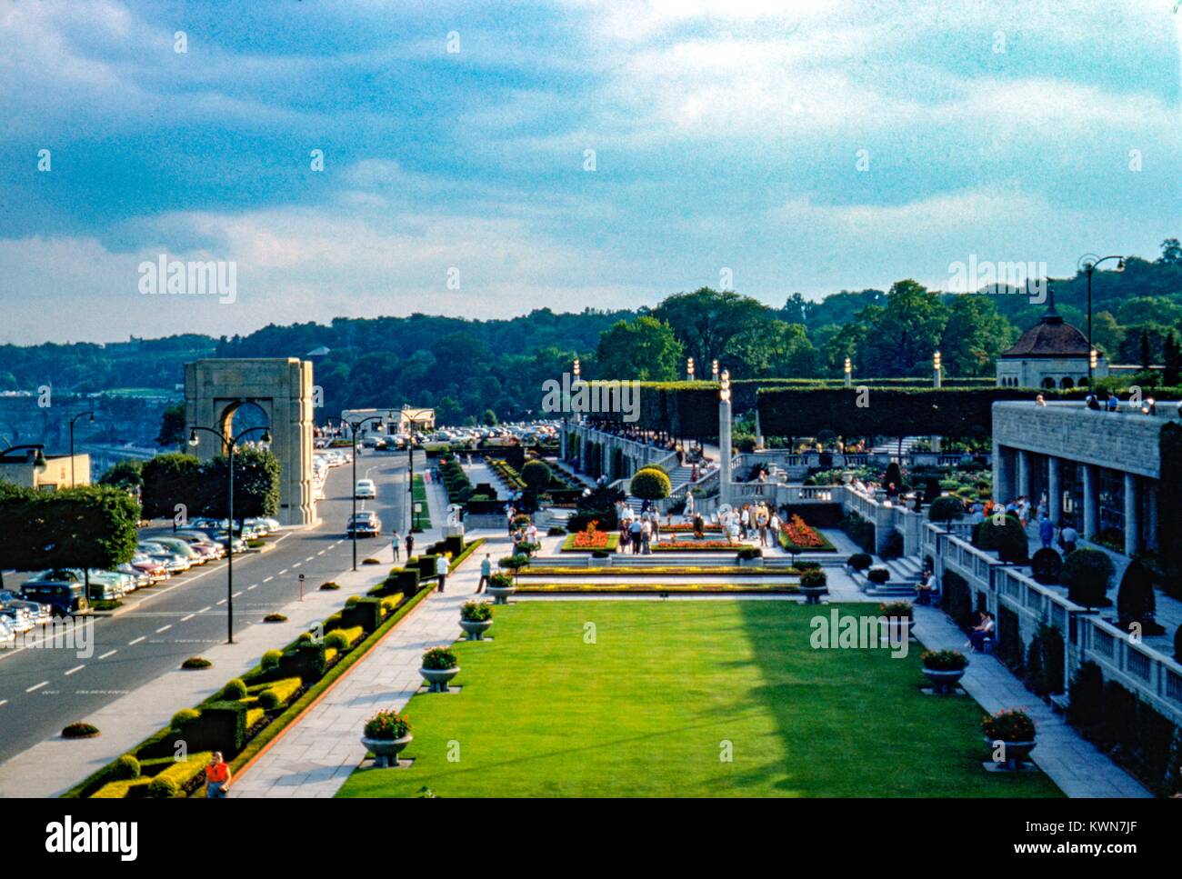 Jardin fleuri et pelouse près de la porte de Clifton House, avec l'Arche commémorative Clifton visible (supprimé en 1967), Niagara Falls, New York, 1950. Banque D'Images