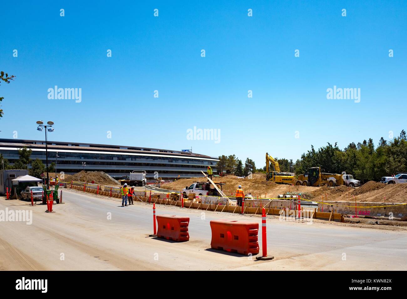 Site de construction avec les travailleurs de la construction et de l'équipement, ainsi qu'une partie du bâtiment principal, à l'entrée de la rue Wolfe Apple Park, connu familièrement comme "le vaisseau spatial", le nouveau quartier général d'Apple Inc dans la Silicon Valley ville de Cupertino, Californie, 25 juillet 2017. Banque D'Images