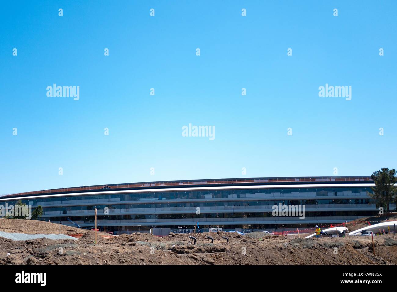 La façade du bâtiment principal est visible au-dessus d'un chantier de construction à l'Apple Park, connu familièrement comme "le vaisseau spatial", le nouveau quartier général d'Apple Inc dans la Silicon Valley ville de Cupertino, Californie, 25 juillet 2017. Banque D'Images