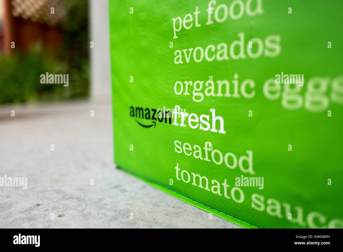 Pack froid vert tote pour Amazon Fresh service de livraison d'épicerie, avec Amazon logo et texte liste d'épicerie qui peuvent être commandés en utilisant le service, à la porte d'une maison de banlieue dans la région de la baie de San Francisco la ville de San Ramon, Californie, le 11 avril 2017. En juin 2017, Amazon a annoncé qu'elle ferait l'acquisition de la chaîne d'épicerie haut de gamme Whole Foods Market d'élargir son offre dans le secteur de l'épicerie. Banque D'Images