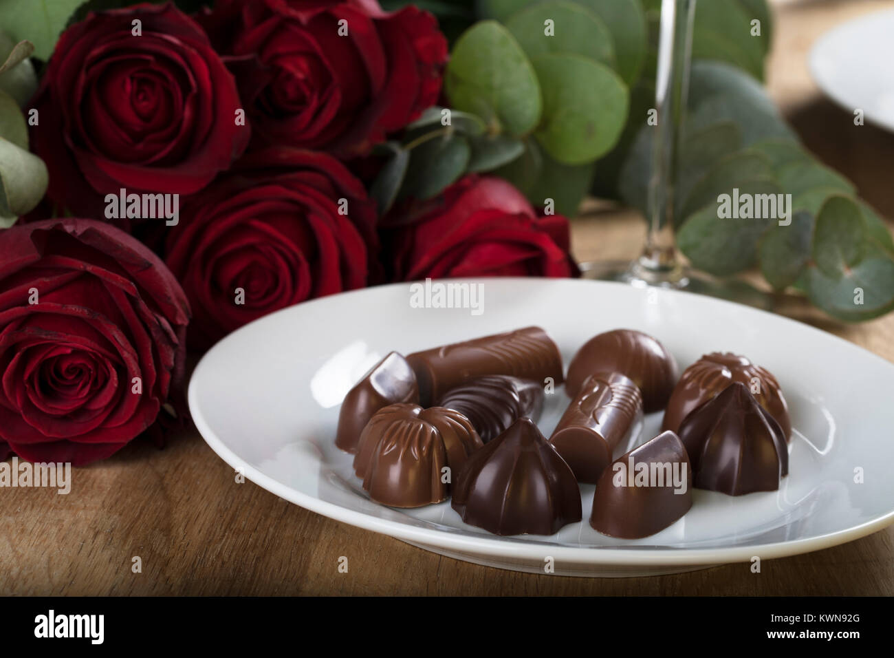 Assiette de chocolats close up avec des roses en arrière-plan Banque D'Images