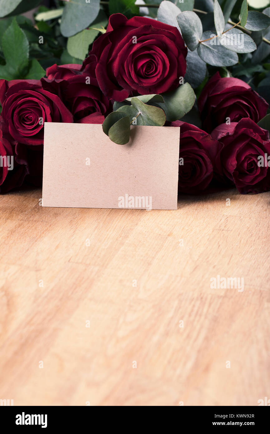 Roses rouge verticale sur table avec carte vierge pour votre message Banque D'Images