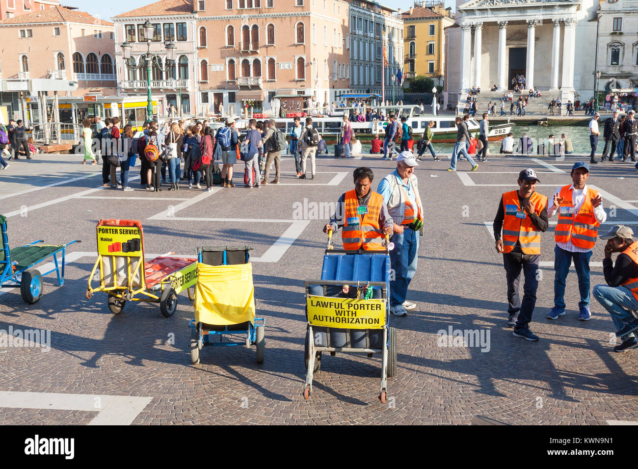 Les porteurs de l'hôtel attendent devant la gare de Santa Lucia, Cannaregio, Venise, Italie de transport de touristes assurance avec leurs chariots Banque D'Images