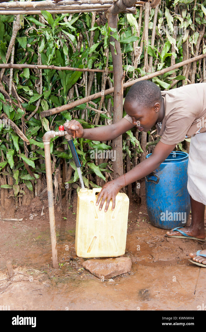 La collecte d'un enfant rwandais de contenant de l'eau d'un tuyau en nouvelle initiative sur l'eau Banque D'Images