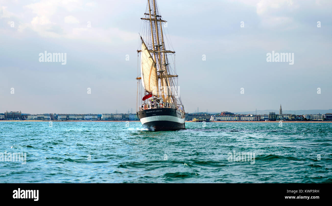 Pelican grand voilier voile de Londres dans la baie de Weymouth, Dorset, UK. Esplanade Weymouth dans la distance Banque D'Images