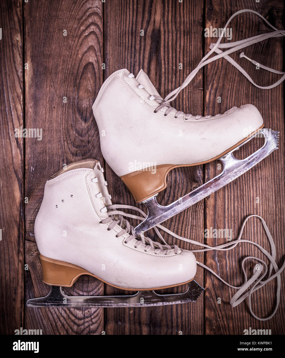 Femme en cuir blanc pour le patinage artistique patins sur un fond en bois brun, vue du dessus Banque D'Images