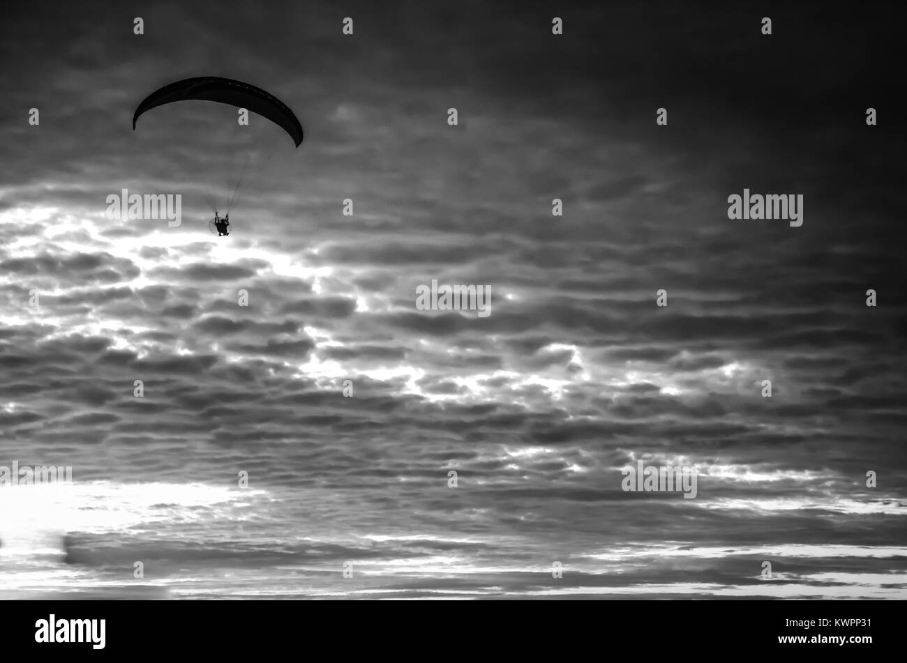 Vol en parapente motorisé haut jusqu'au ciel par le coucher du soleil Banque D'Images