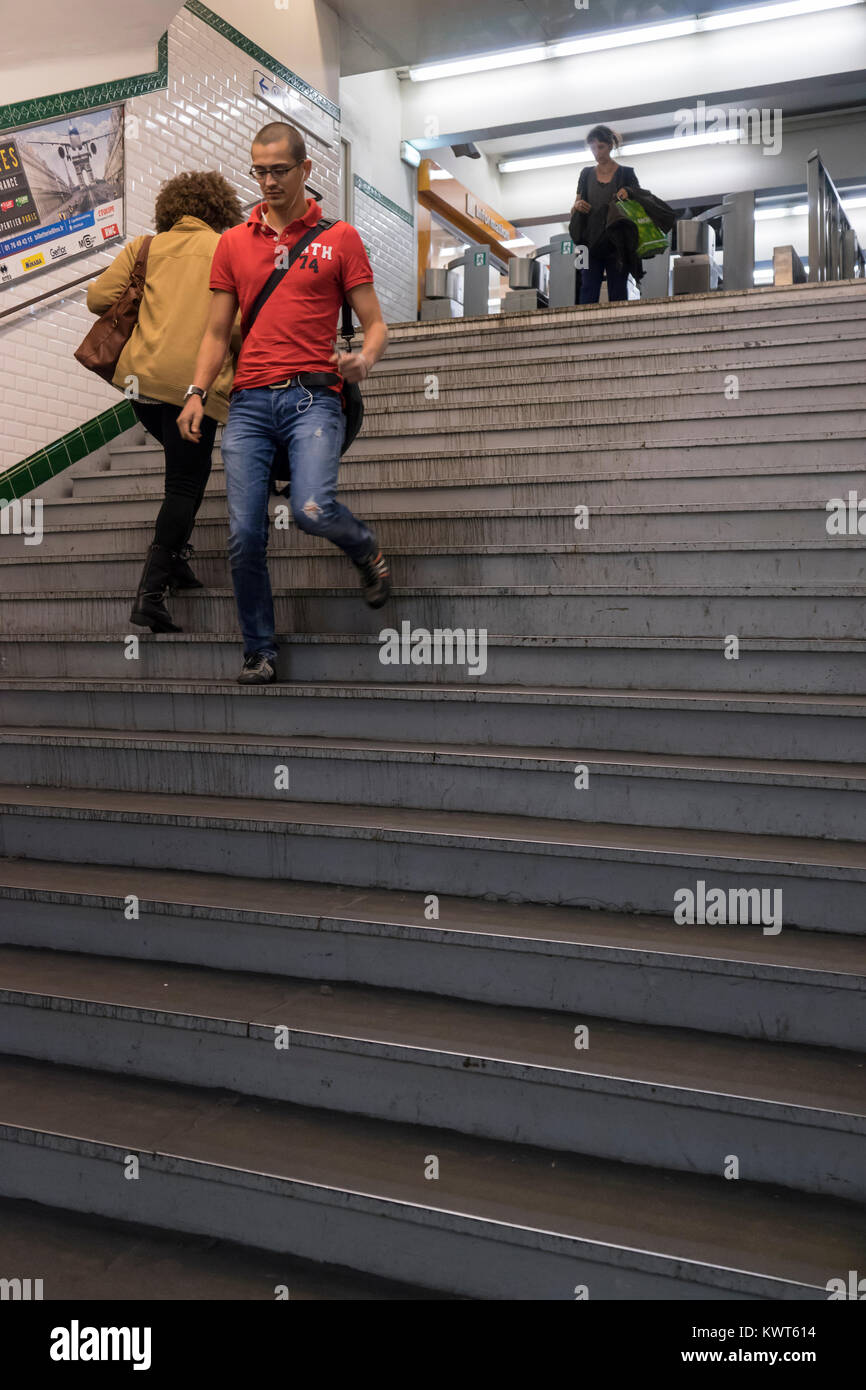 France, Paris, jeune homme qui courait dans les escaliers à l'entrée de métro. Banque D'Images