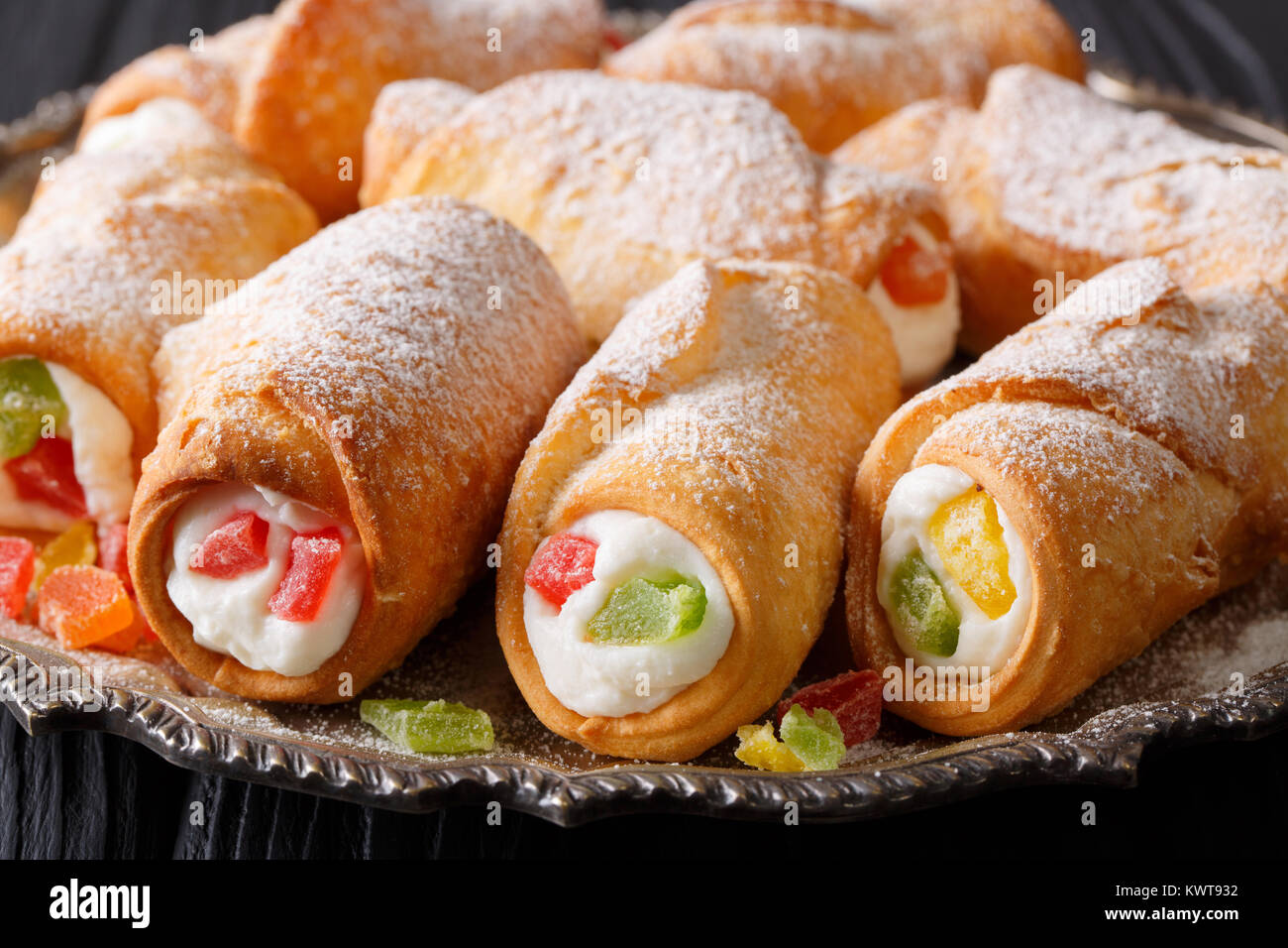 Cuisson sicilienne cannoli avec crème au fromage et fruits confits macro sur une plaque horizontale. Banque D'Images