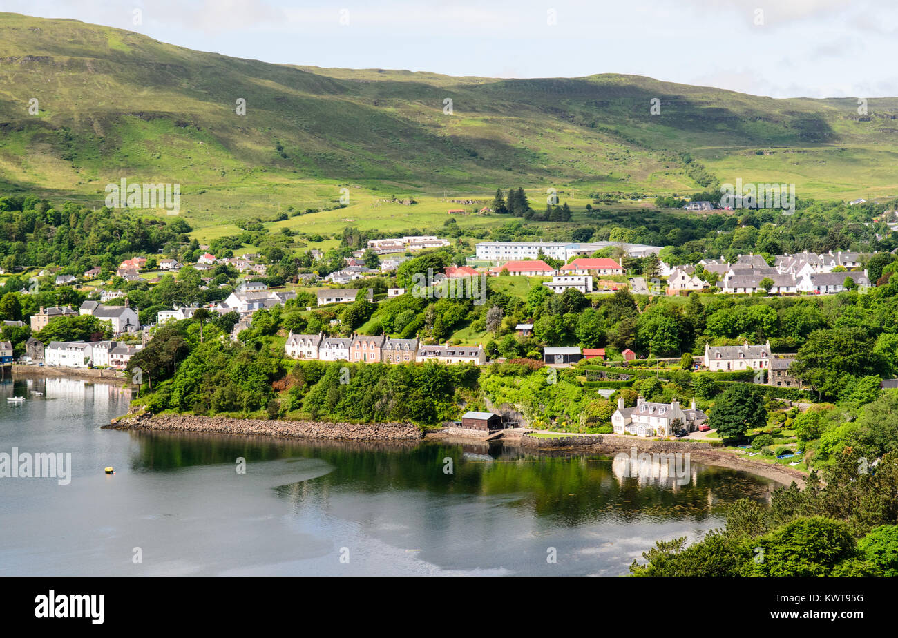 Les maisons sont nichés parmi les arbres sur la côte sous les montagnes de l'île de Skye à Portree dans l'ouest des Highlands d'Écosse. Banque D'Images