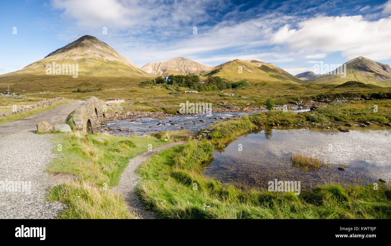 Old Stone arch bridge sur une rivière de montagne à Sligachan sur l'île de Skye dans les Highlands d'Écosse, avec les montagnes de l'augmentation des Cuillin Banque D'Images