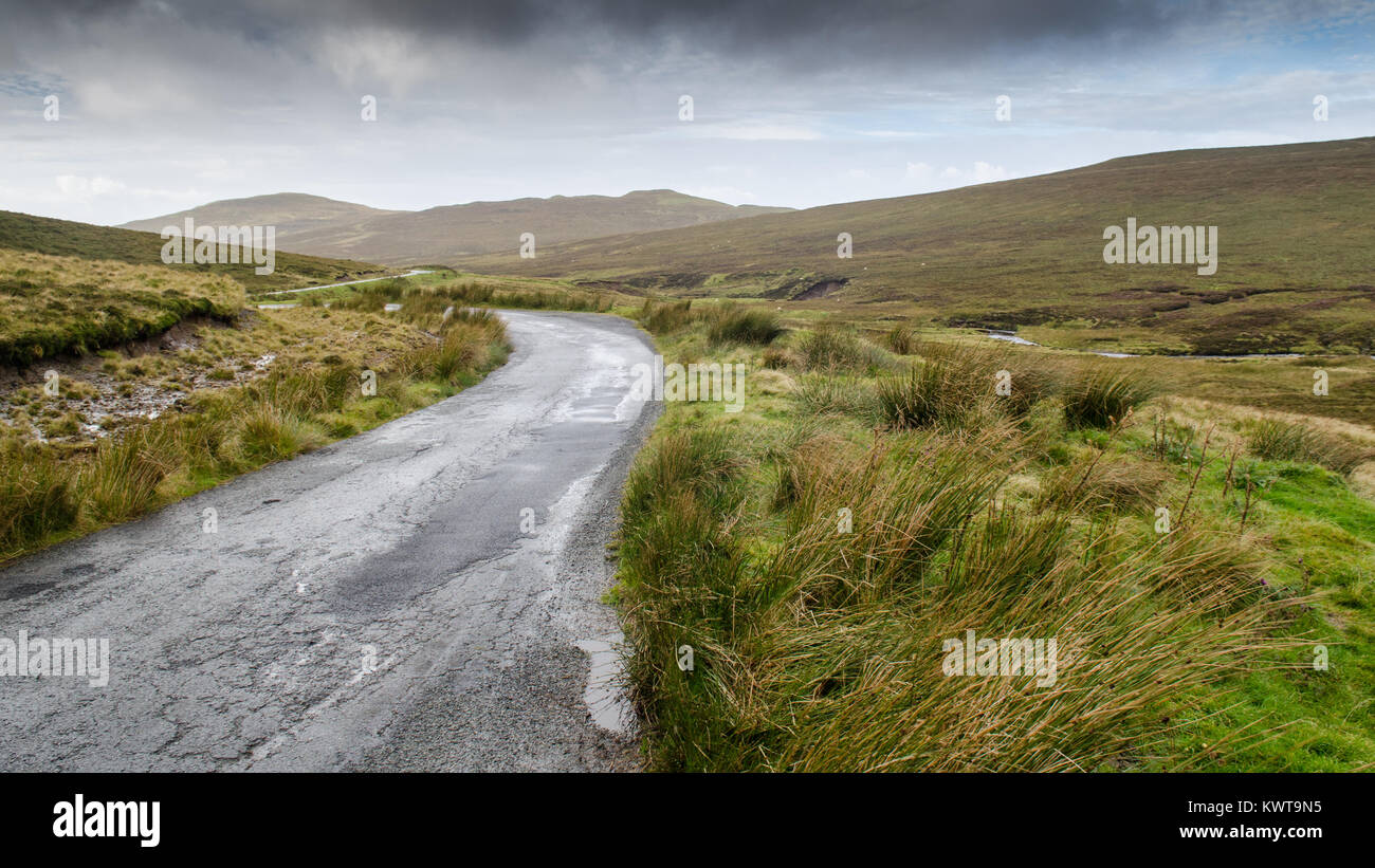 Une route de campagne à voie unique à travers la lande de montagne vents humides à la péninsule de Trotternish Quiraing sur de l'île de Skye dans les West Highlands de l'al. Banque D'Images