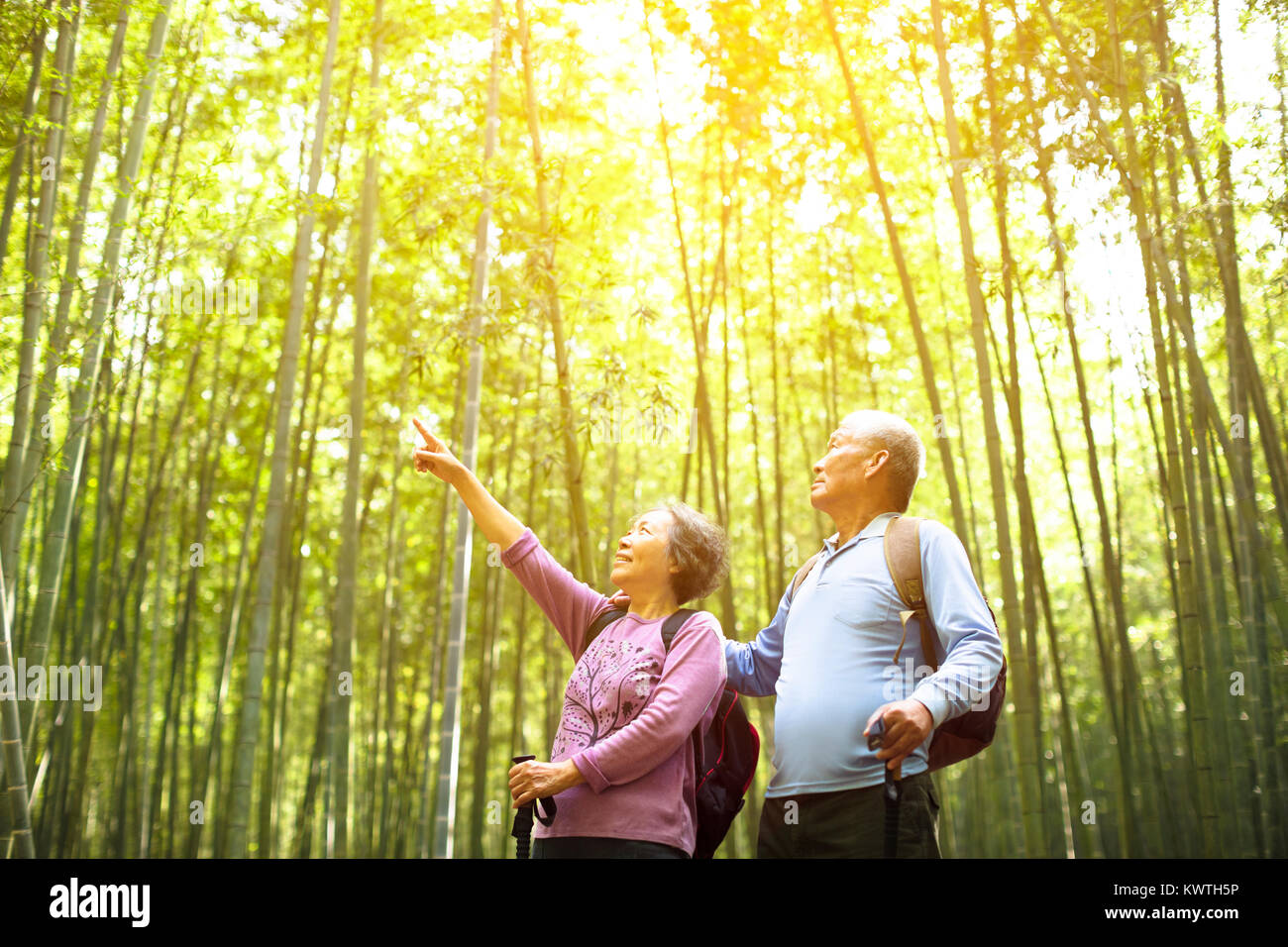 Senior Couple randonnées en forêt de bambou vert Banque D'Images