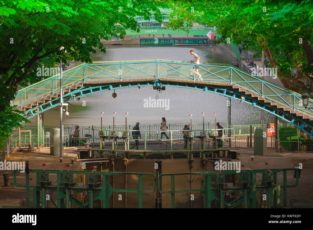 Paris Canal Saint-Martin, l'homme reprend sa course à travers une passerelle enjambant le canal Saint-Martin dans le 10ème arrondissement de Paris, France. Banque D'Images