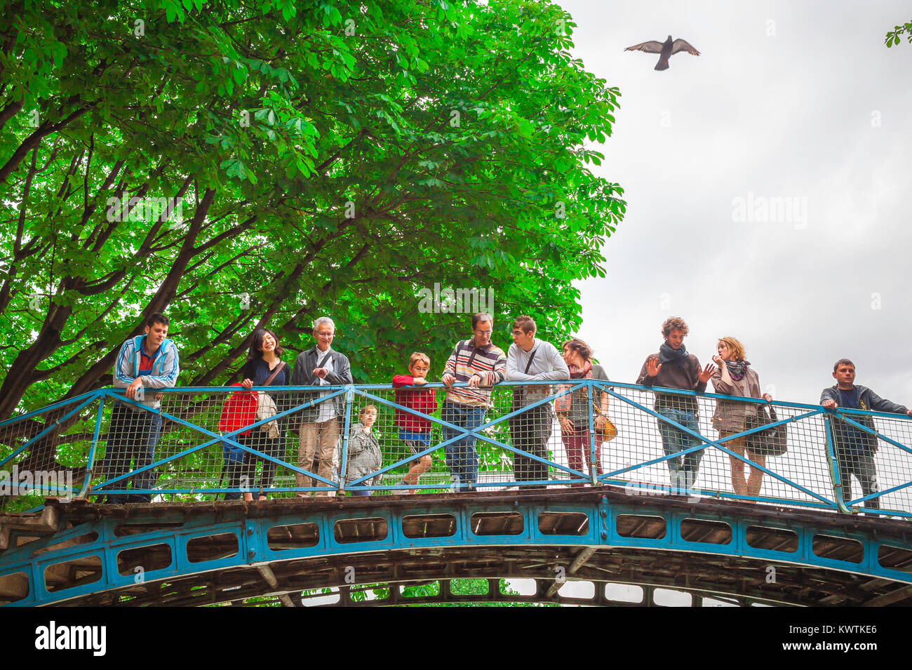 Paris Canal Saint Martin, les touristes regarder à partir d'un pont qu'un bateau passe par une serrure en dessous d'eux sur le Canal Saint-Martin, dans le centre de Paris, France. Banque D'Images