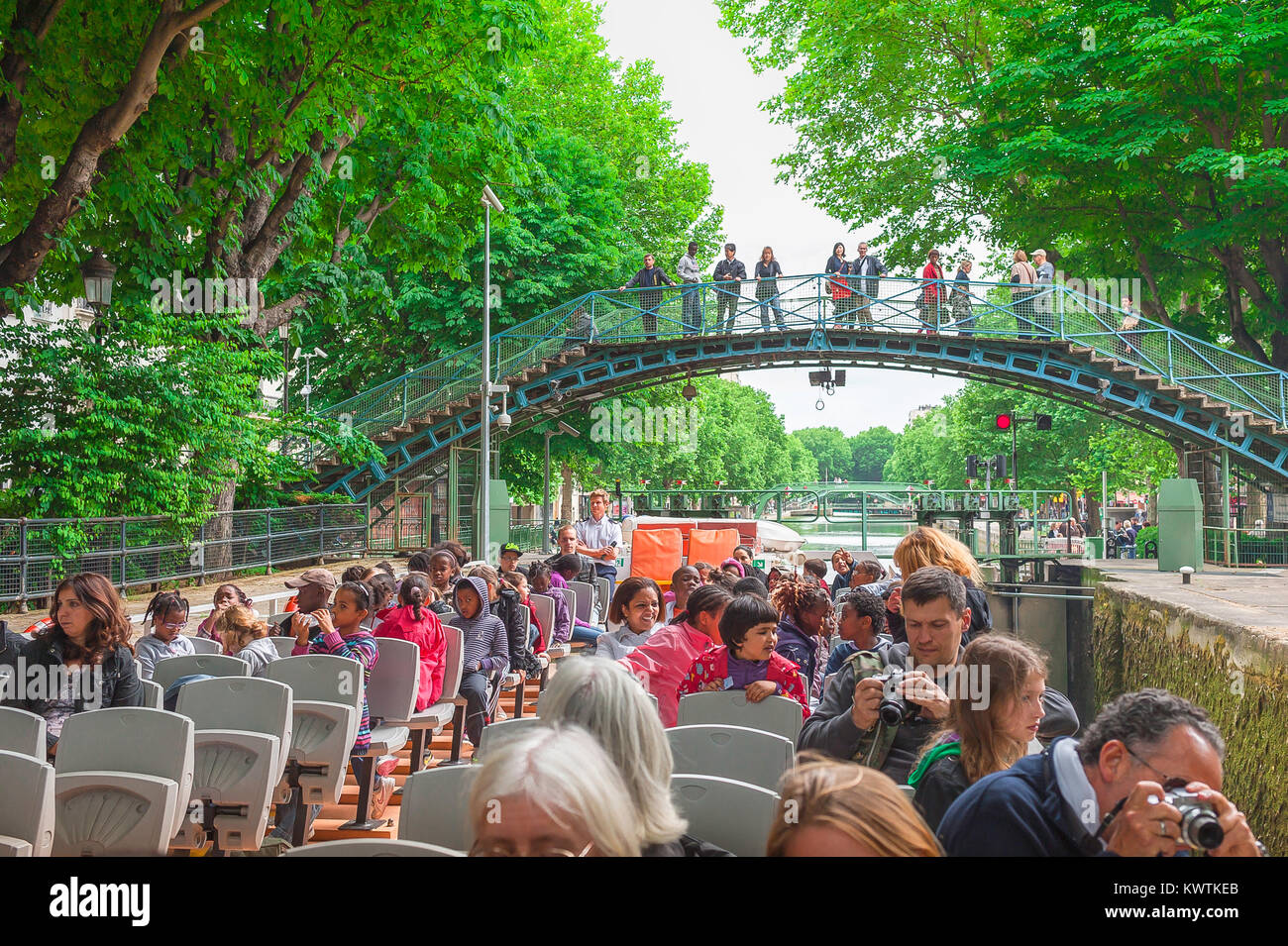 Visite du canal Saint-Martin de Paris, vue à la fin du printemps d'un bateau transportant des touristes sur le canal Saint-Martin dans le centre de Paris, France. Banque D'Images