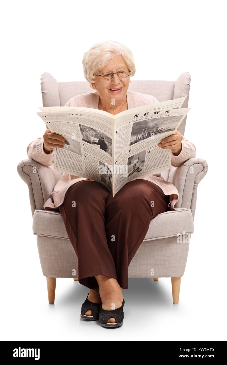 Femme âgée assise sur un fauteuil et de lire un journal isolé sur fond blanc Banque D'Images