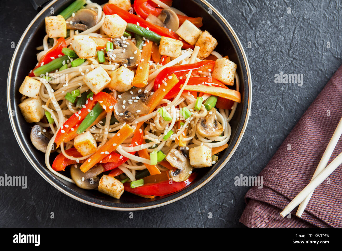Faire revenir avec les nouilles Udon, tofu, champignons et légumes. La  nourriture végétarienne, végétalienne asiatique, repas sautés au wok à fond  noir, copiez l'espace Photo Stock - Alamy