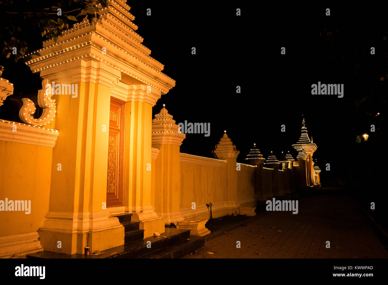 Un mur jaune orange allumé et la porte de nuit à Phnom Penh au Cambodge, en Asie du sud-est, à proximité de Sisowath Quay et du fleuve Tonle Sap Banque D'Images