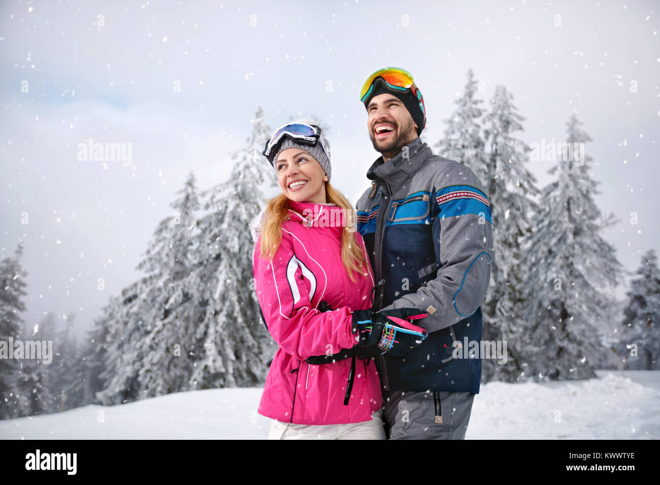 Smiling couple heureux ensemble sur la montagne pour vacances hiver Banque D'Images