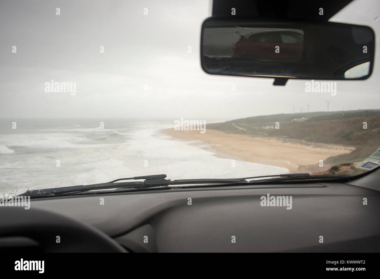 Voir former à l'intérieur d'une voiture en stationnement à la plage un jour pluvieux et venteux en vacances à Praia do Norte Portugal Banque D'Images