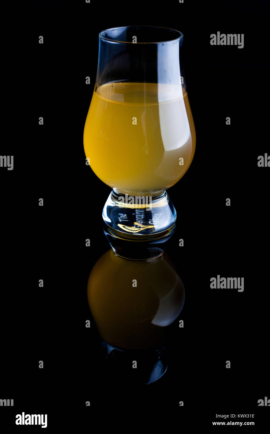 Vinaigre de pomme en verre transparent sur fond noir avec reflet Banque D'Images