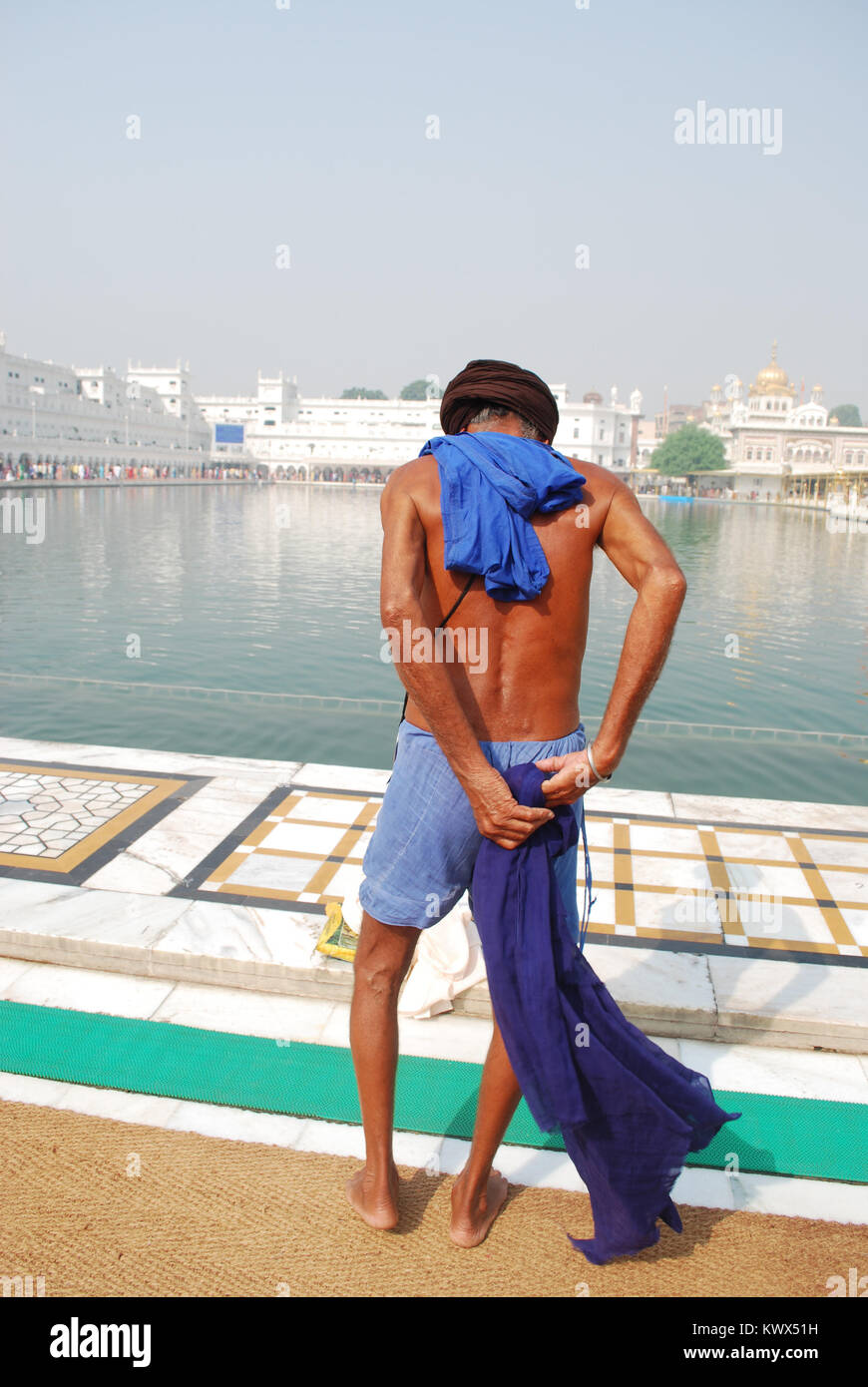 Un Sikh s'apprête à se baigner dans les eaux au Sri Harmandir Sahib, également connu sous le nom de Golden Temple, Amritsar, Inde Banque D'Images