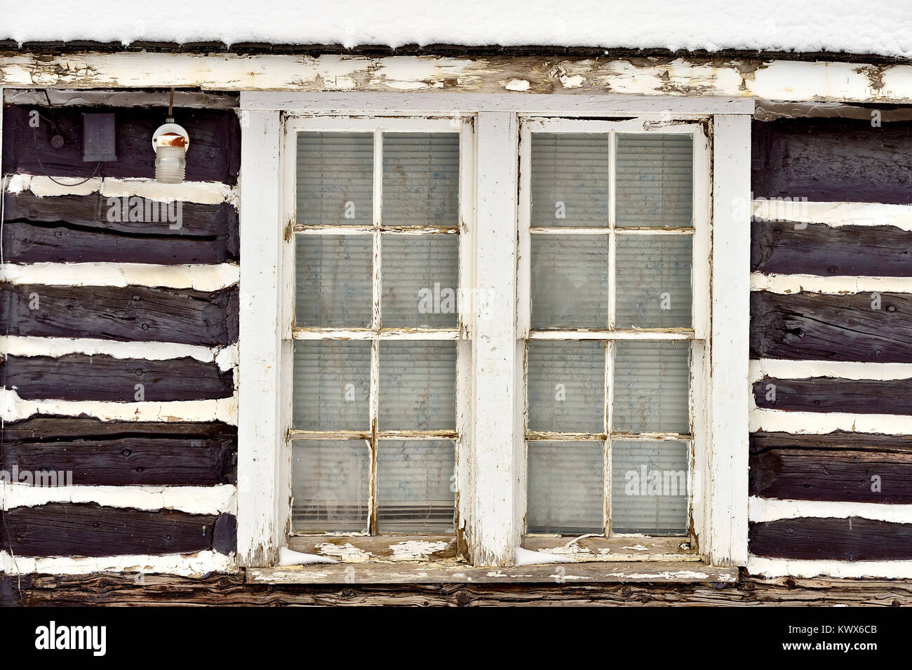 La fenêtre sur le côté d'une cabane avec boucher paniers entre les rondins. Banque D'Images