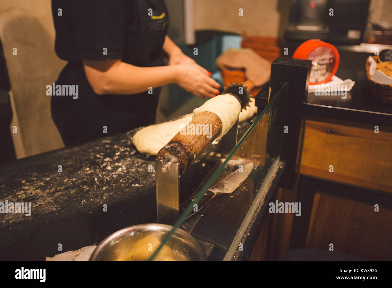 Les mains d'une femme baker sont la cuisson ou trdelnik Trdlo dans une agréable ville cafe un traitement national en République tchèque dans l'hiver Banque D'Images