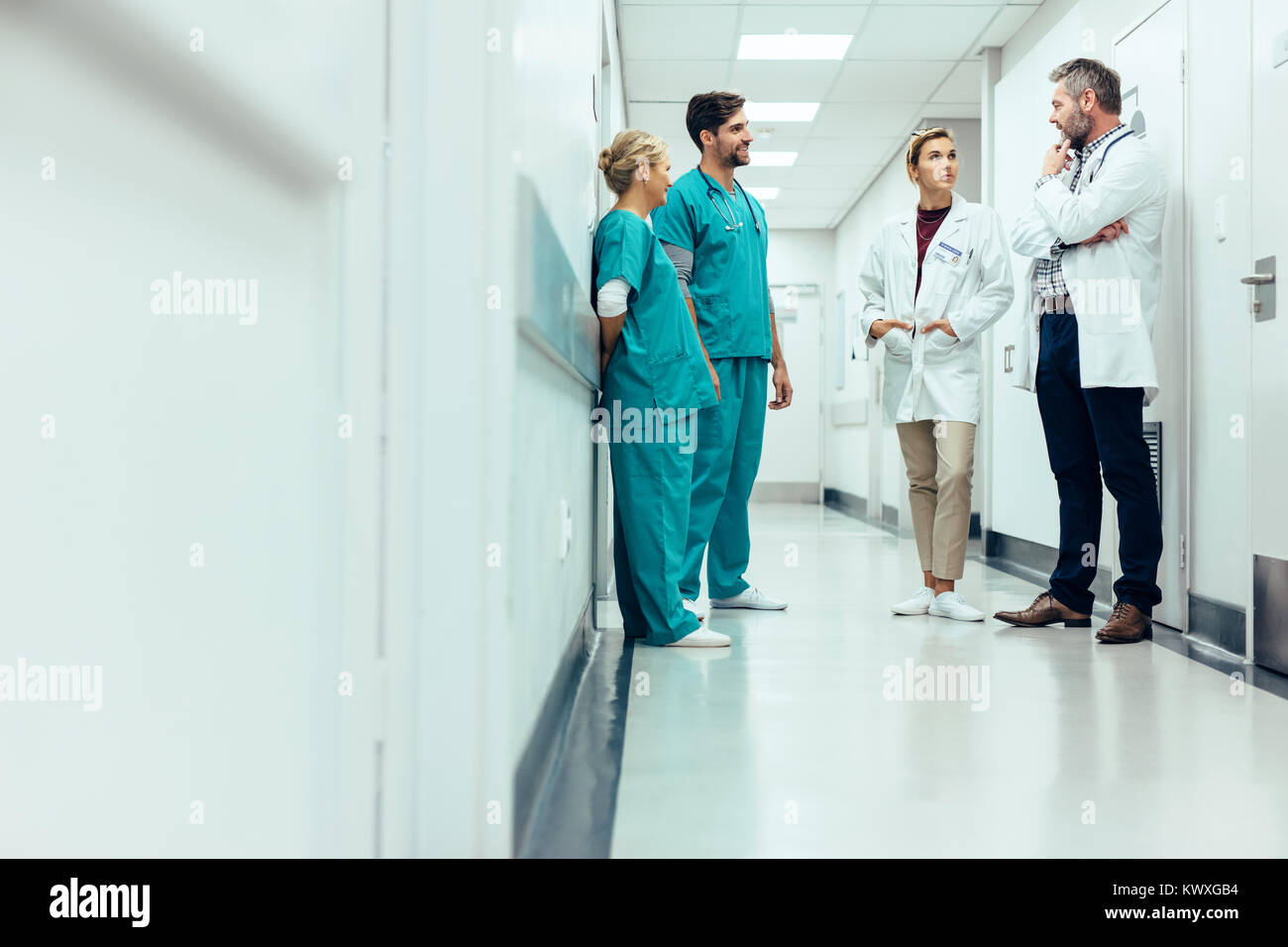 Groupe de personnel médical discuter dans le couloir de la clinique. Les professionnels de santé ayant discussion dans couloir de l'hôpital. Banque D'Images