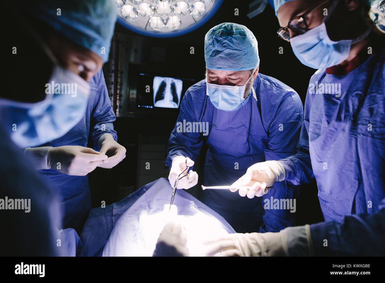 Les médecins pendant la chirurgie à l'hôpital. Équipe de chirurgiens professionnels travaillant à l'hôpital d'effectuer une procédure chirurgicale en salle d'opération. Banque D'Images