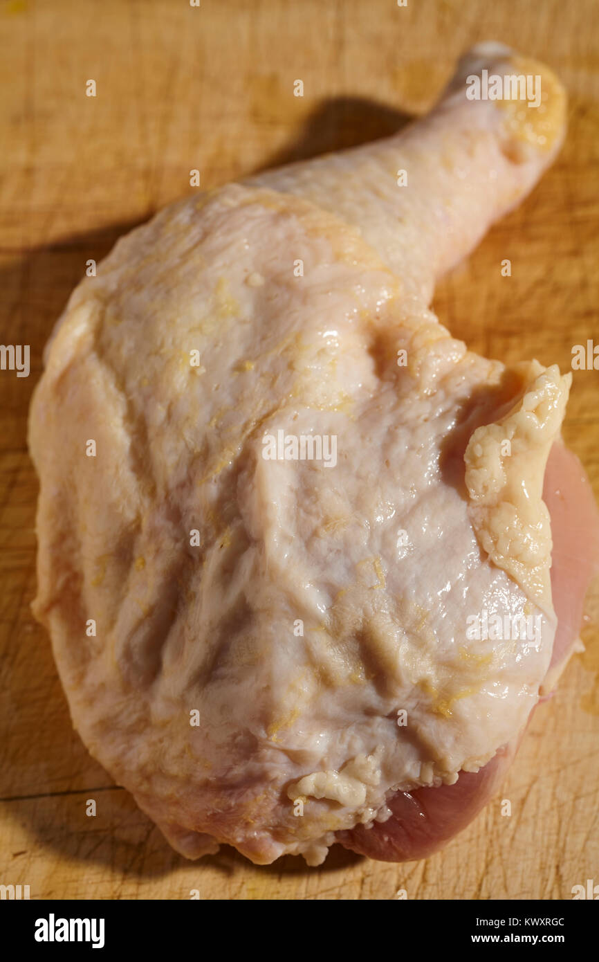 Jambe et la cuisse de poulet crue sur un bloc de boucher en bois Banque D'Images