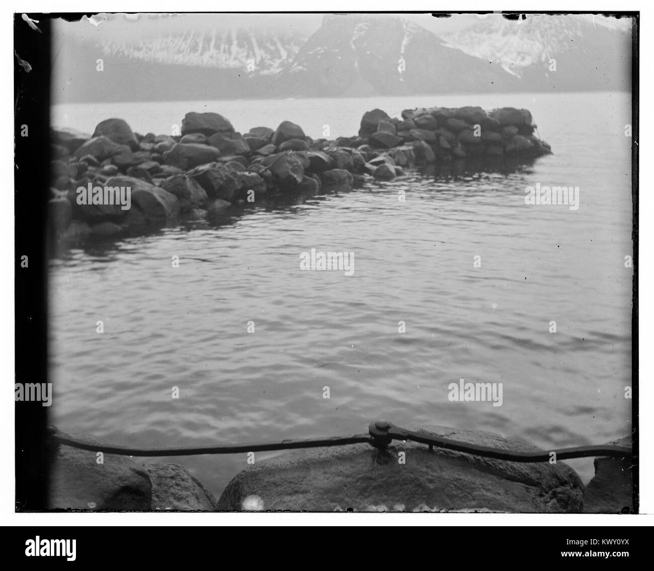 Photographie historique de Mefjordvær dans le comté de Tromsø, Norvège. L'image capture le village de pêcheurs côtier, montrant des maisons en bois traditionnelles, des bateaux et le paysage naturel caractéristique du nord de la Norvège. Banque D'Images