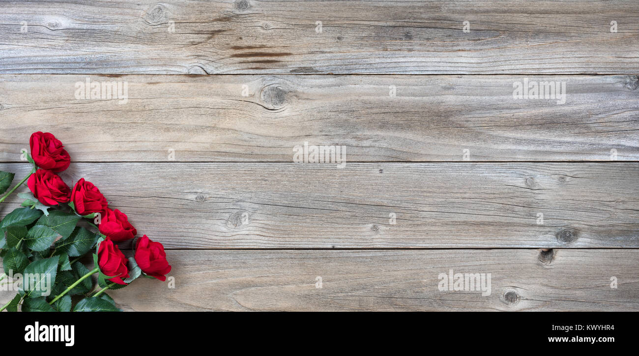 Roses rouges dans le coin inférieur gauche sur bois rustique en vue mise à plat Banque D'Images