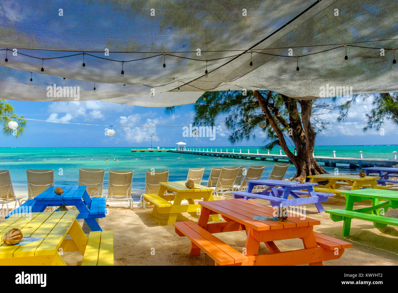 Grand Cayman, îles Caïmans, vue sur la mer des Caraïbes depuis quelques tables multicolores sur la plage de Rum point Banque D'Images