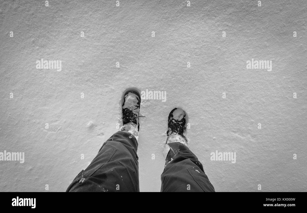 À la perspective de Dow sur hikker bottes sur la neige fraîche. Le noir et blanc modifier Banque D'Images