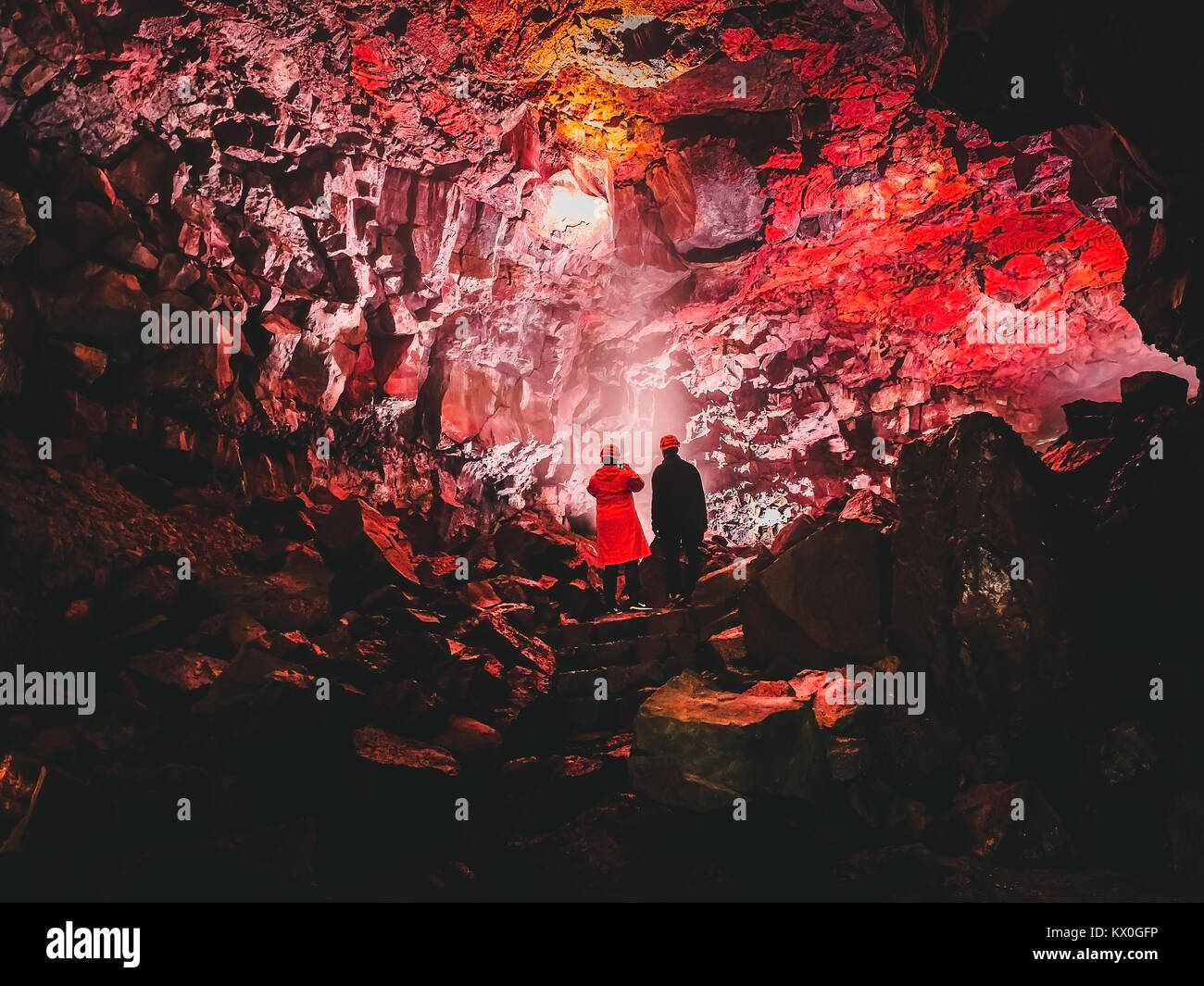 Deux touristes à l'intérieur du tunnel de lave rouge magnifique Raufarholshellir près de Reykjavik, Islande Banque D'Images
