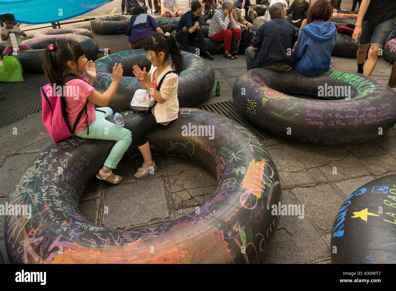 Deux filles asiatiques jouer patty-cake sur le tube intérieur, Paris, France Banque D'Images Deux filles asiatiques jouer patty-cake sur le tube intérieur, Paris, France Banque D'Images