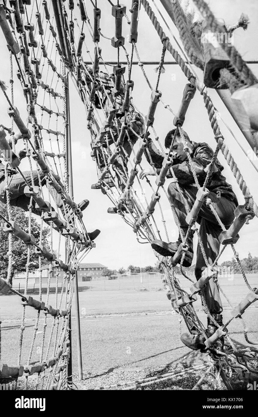 Armée britannique squaddies subissant la formation de base grimper sur filets de corde dans le cadre d'une course d'obstacles, le 15 juin 1993 Banque D'Images