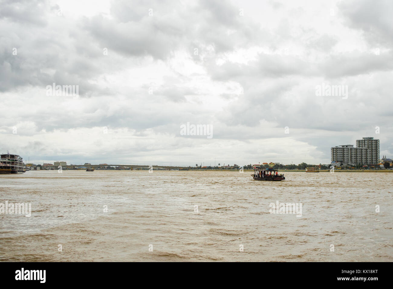 Traversée de la rivière Tonle Sap par bateau à Phnom Penh Cambodge, avec ciel nuageux ciel de pluie pendant la mousson, le Japon Cambodge Pont de l'amitié à distance Banque D'Images